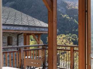 Experience breathtaking mountain views from this charming wooden balcony, perfect for enjoying your morning coffee or evening wine.