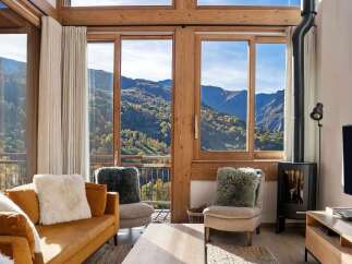 Experience breathtaking mountain views from this stunning living room, featuring a cozy fireplace and comfortable seating.