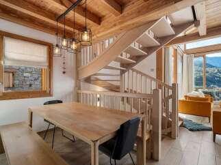 Experience cozy mountain living in this charming chalet, featuring a warm wooden interior and a stunning spiral staircase.