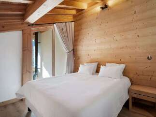 Experience cozy mountain living in this charming bedroom featuring a comfortable bed with crisp white linens, perfect for unwinding after a day of adventure.