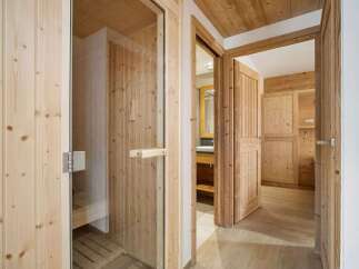 Experience ultimate relaxation in this luxurious wooden sauna, featuring a glass door and comfortable benches.