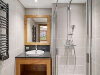 Experience modern comfort in this beautifully appointed bathroom, featuring a sleek vanity with a vessel sink and a spacious walk-in shower.