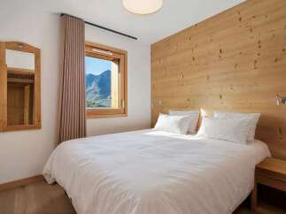 Experience cozy mountain living in this charming bedroom, featuring a comfortable queen-size bed with crisp white linens.