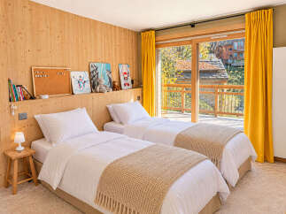 Experience cozy comfort in this charming bedroom featuring two twin beds, perfect for families or guests.