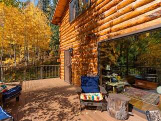 Experience the beauty of autumn from this stunning log cabin's expansive deck.