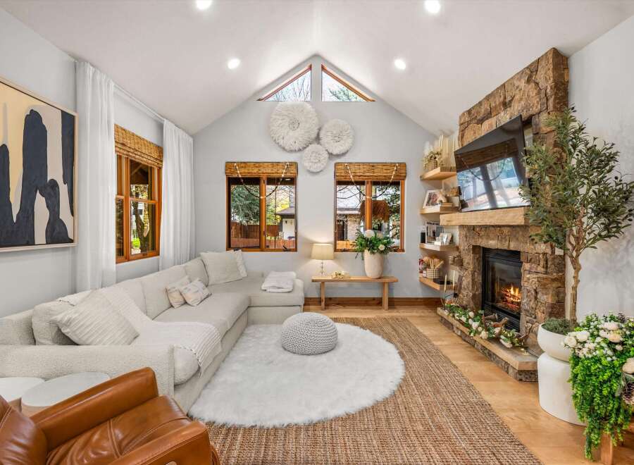 Experience cozy living in this inviting living room, featuring a stunning floor-to-ceiling stone fireplace as the focal point.