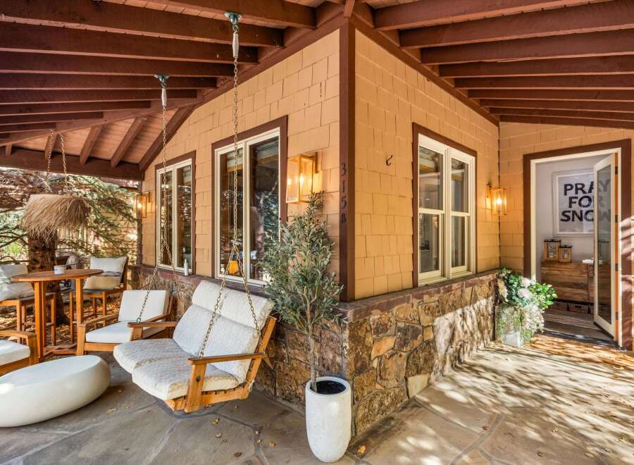 Enjoy the outdoors on this charming covered porch, complete with a comfortable swing and a cozy seating area.