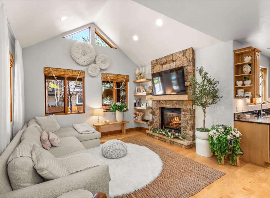 Experience cozy living in this inviting living room, featuring a stunning stone fireplace as the focal point.