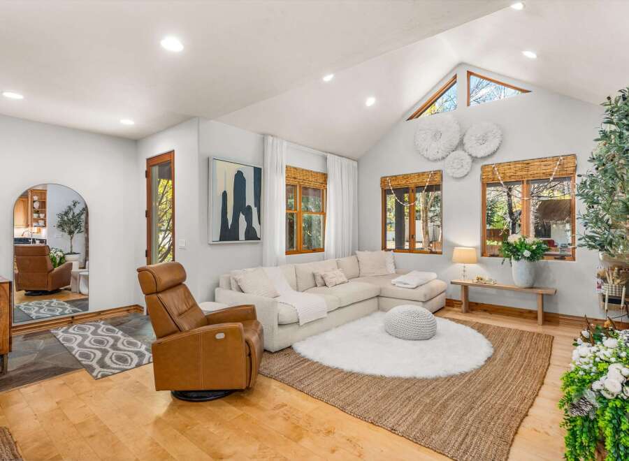 Step into this inviting living room, featuring a plush sectional sofa and a comfortable leather recliner, perfect for relaxation.