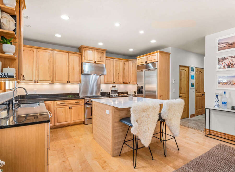 This spacious kitchen boasts custom light wood cabinetry, offering ample storage and a warm, inviting aesthetic.
