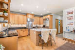 This spacious kitchen boasts custom light wood cabinetry, offering ample storage and a warm, inviting aesthetic.