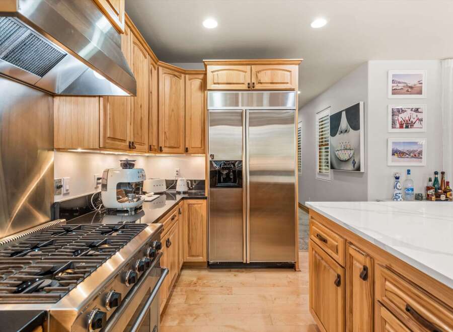 Experience culinary excellence in this stunning kitchen, featuring a professional-grade gas range and a sleek stainless steel range hood.