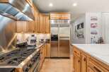 Experience culinary excellence in this stunning kitchen, featuring a professional-grade gas range and a sleek stainless steel range hood.