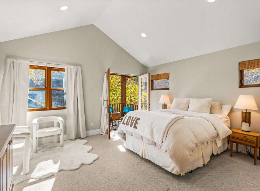 Experience ultimate comfort in this inviting bedroom, featuring a plush queen-size bed adorned with a 'LOVE' throw blanket.