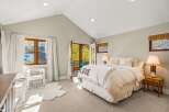 Experience ultimate comfort in this inviting bedroom, featuring a plush queen-size bed adorned with a 'LOVE' throw blanket.