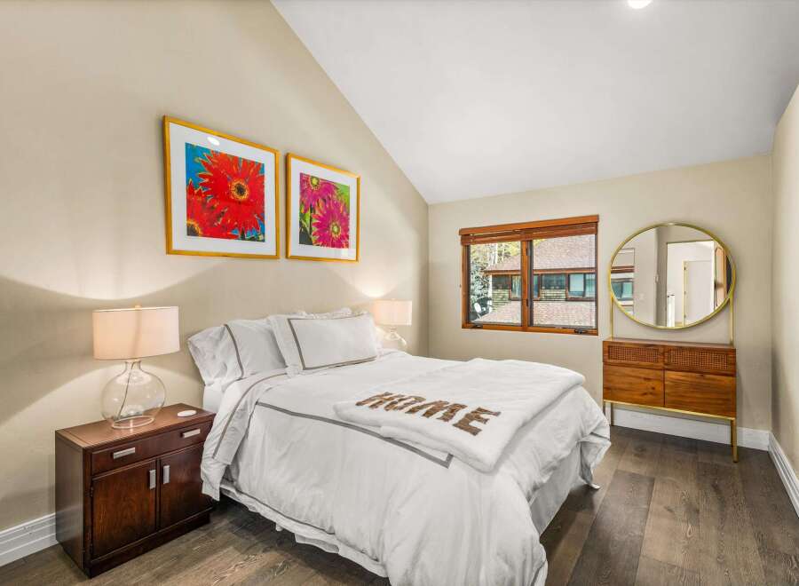 Experience comfort and style in this inviting bedroom, featuring a plush queen-size bed adorned with crisp white linens and a cozy throw blanket.