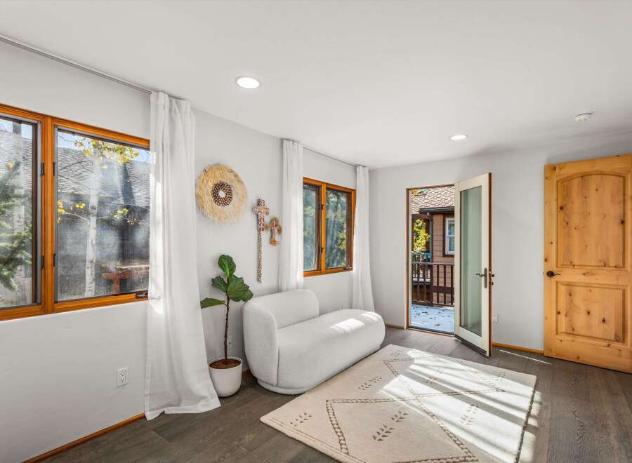 Step into a bright and airy living space featuring large wooden-framed windows that flood the room with natural light.