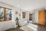 Step into a bright and airy living space featuring large wooden-framed windows that flood the room with natural light.
