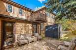 Enjoy outdoor living in this charming backyard featuring a concrete patio adorned with fallen leaves, perfect for a serene autumn setting.