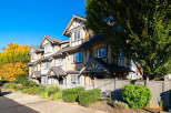Discover charming townhomes with classic architectural details, featuring warm siding and contrasting trim.