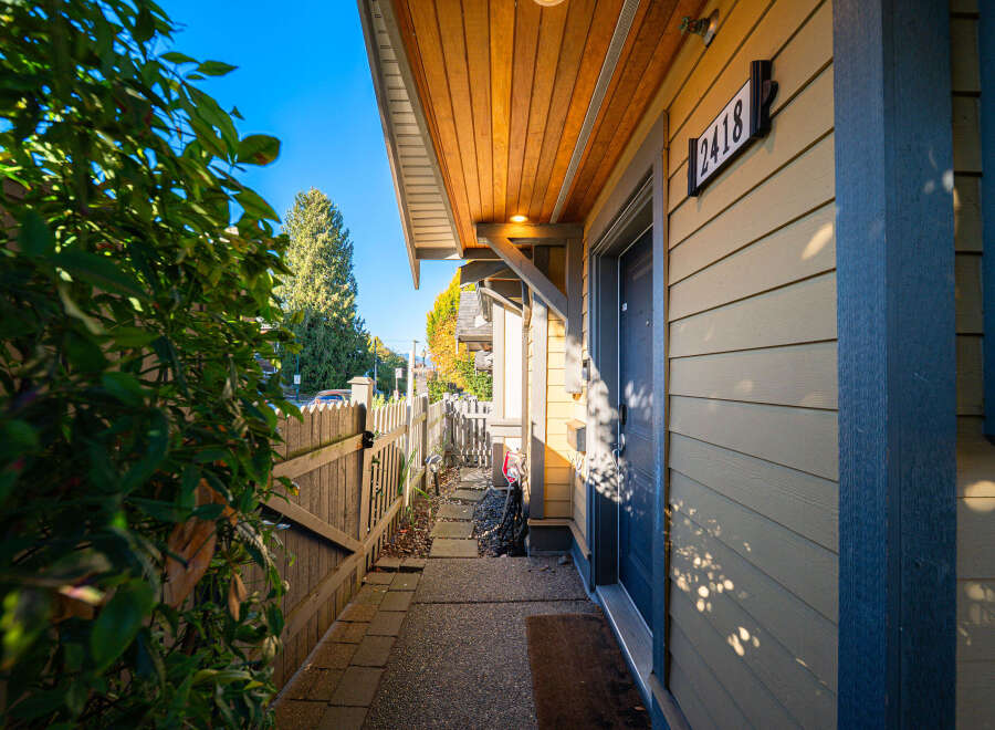 Welcome to this charming home featuring a welcoming entryway with a covered porch and a clear house number '2418'.