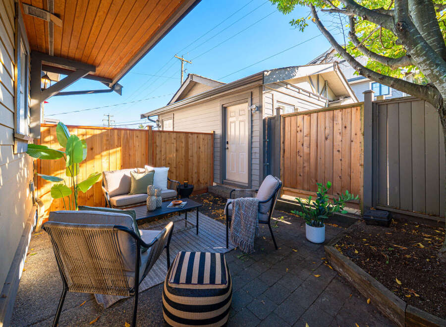 Enjoy outdoor living in this charming patio space, complete with comfortable seating and a coffee table.