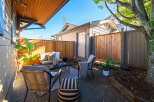 Enjoy outdoor living in this charming patio space, complete with comfortable seating and a coffee table.