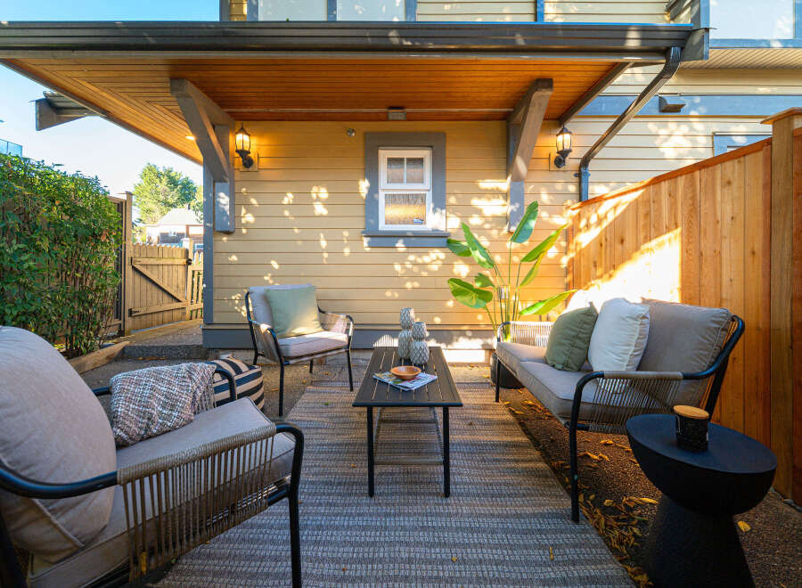 Enjoy outdoor living in this charming patio space, complete with comfortable seating and a modern coffee table.