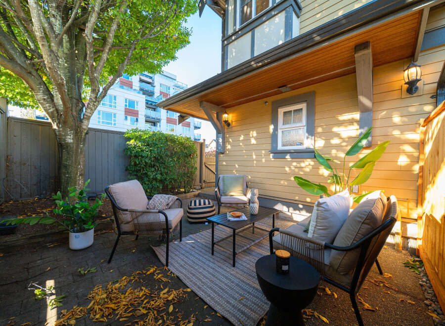 Enjoy your morning coffee or evening drinks in this charming backyard patio, complete with comfortable seating and a coffee table.