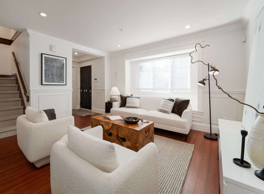 Step into this inviting living room, featuring plush white boucle armchairs and a comfortable sofa perfect for relaxation.