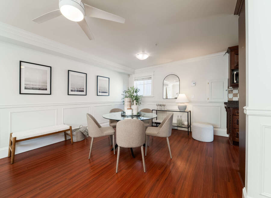 This elegant dining area features a sleek glass-top dining table surrounded by four upholstered chairs, perfect for intimate gatherings.