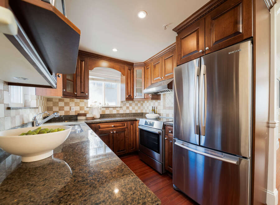 This beautifully appointed kitchen features rich, dark wood cabinetry providing ample storage and a classic aesthetic.