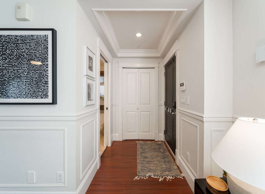 Step into this elegant hallway featuring rich hardwood floors and sophisticated wainscoting.