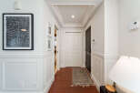Step into this elegant hallway featuring rich hardwood floors and sophisticated wainscoting.