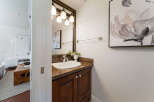 This elegant powder room features a granite-topped vanity with a white undermount sink and a polished chrome faucet.