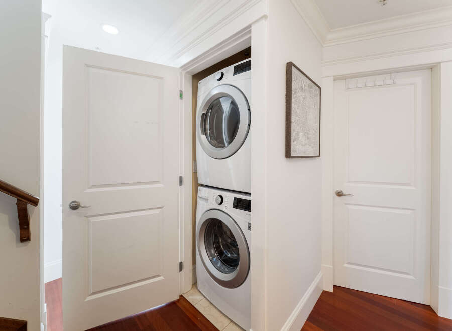 This modern laundry room features a stacked LG washer and dryer, efficiently maximizing space within a closet.