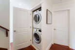 This modern laundry room features a stacked LG washer and dryer, efficiently maximizing space within a closet.