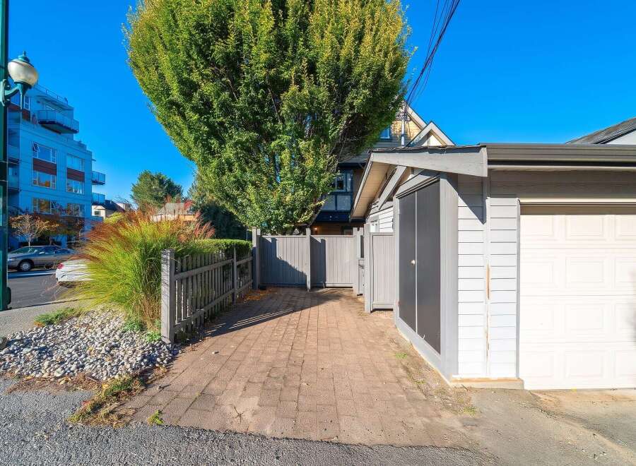 Discover this charming property featuring a paved driveway leading to a spacious garage, perfect for vehicle storage or a workshop.