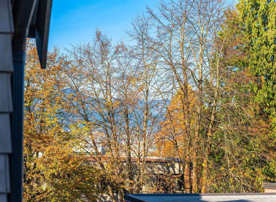 Experience the beauty of autumn from this property, offering stunning views of colorful foliage against a clear blue sky.