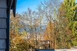 Experience the beauty of autumn from this property, offering stunning views of colorful foliage against a clear blue sky.