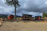 Discover this unique property featuring a modern cabin with a wraparound deck, a charming barrel sauna, and a separate outbuilding.