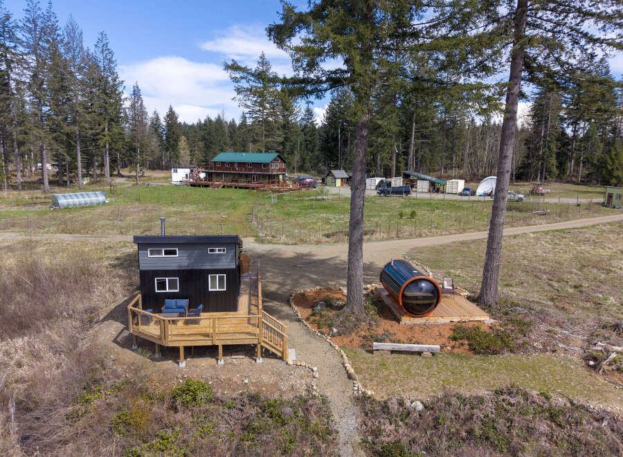 Discover this unique property featuring a modern tiny home with a spacious deck, perfect for outdoor living.