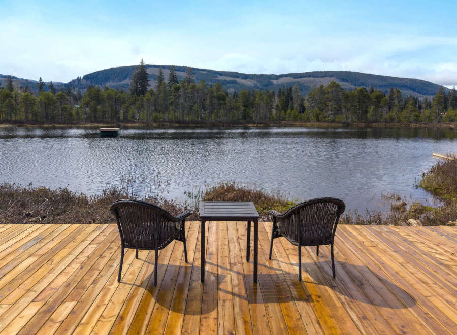 Enjoy serene lakefront living from this charming outdoor seating area.