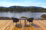 Enjoy serene lakefront living from this charming outdoor seating area.