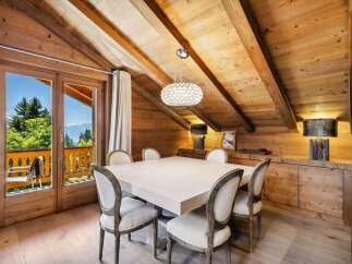 Experience luxurious mountain living in this stunning dining room, featuring a grand square table surrounded by elegant upholstered chairs.