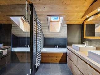 Experience luxury in this modern bathroom featuring a spacious soaking tub and a sleek double vanity with undermount sinks.