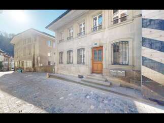 Charming European-style building with a classic wooden door and ornate window grills.