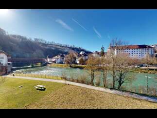 Experience the charm of this picturesque riverside property, featuring a unique covered bridge and a vibrant townscape.