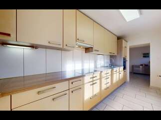 This modern kitchen boasts sleek, light-colored cabinetry and a durable countertop, perfect for meal preparation.