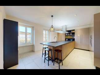 Experience modern living in this stunning kitchen featuring a large island with a built-in sink and ample seating.